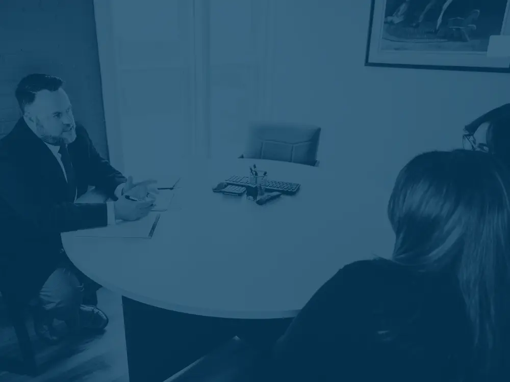patrick sloan from FDT law sitting at a table talking with two clients